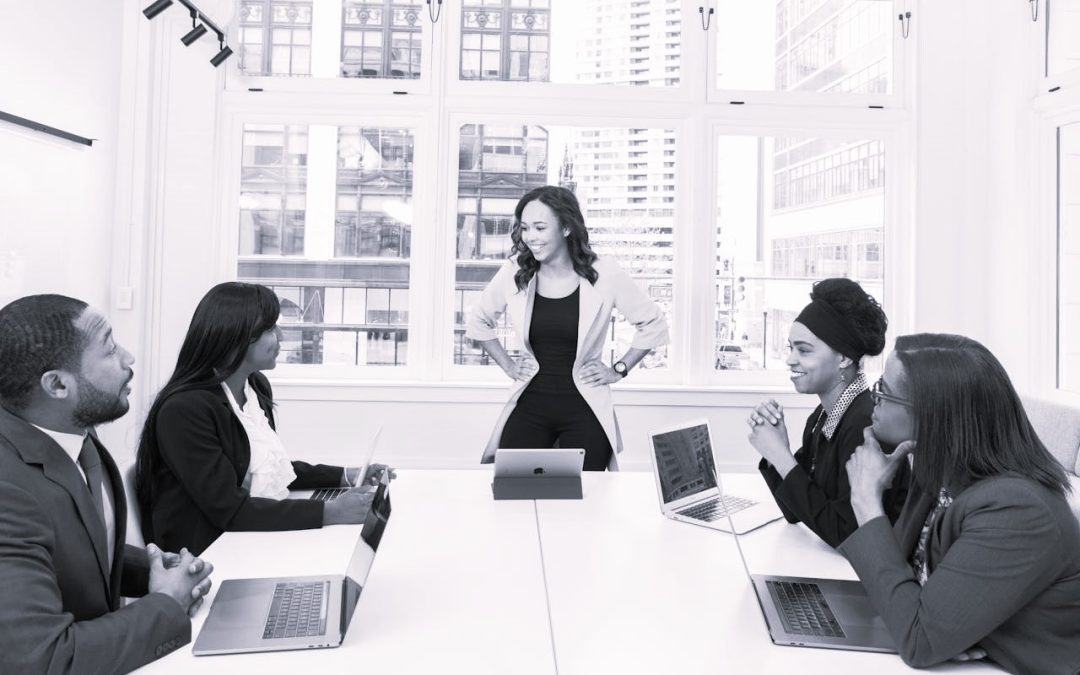 woman leader with hands on hips in front of team