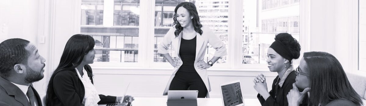 woman leader with hands on hips in front of team