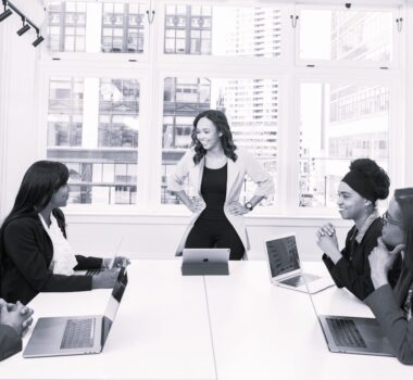 woman leader with hands on hips in front of team