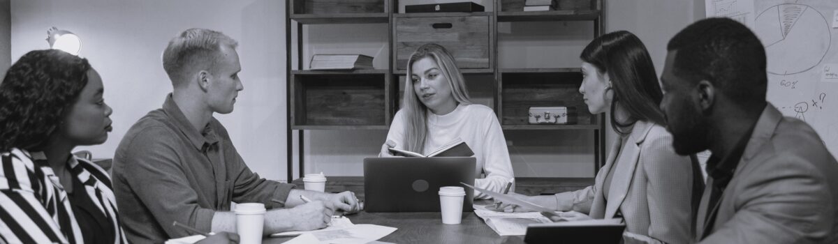 men and women discussion around a table