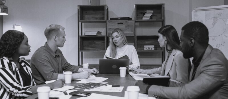 men and women discussion around a table