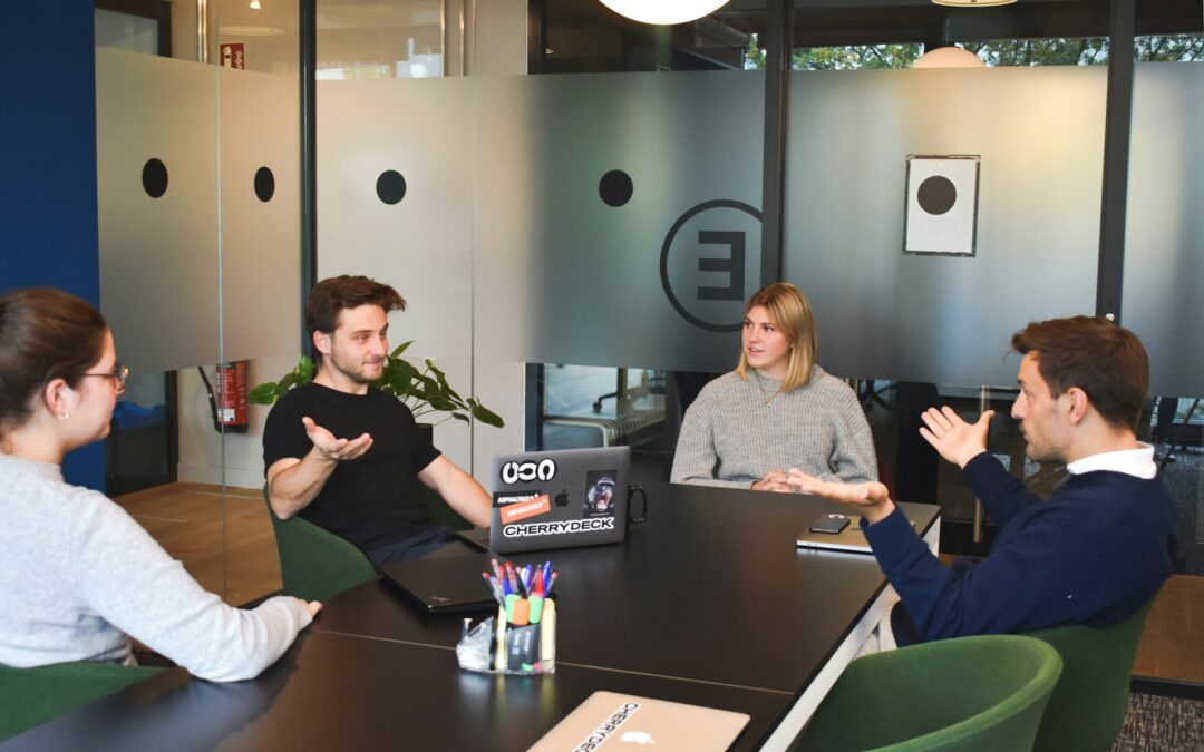 team learning; women and men at work sitting at a table discussing